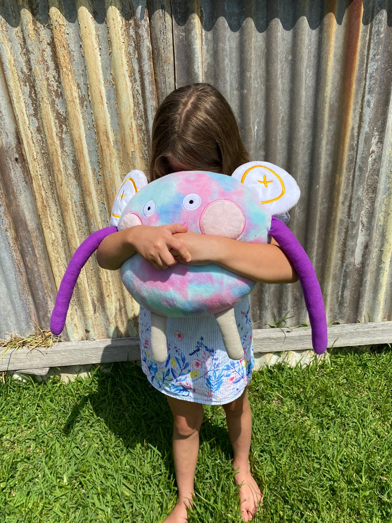 The Big Hug Cuddle toy in the arms of a child. 